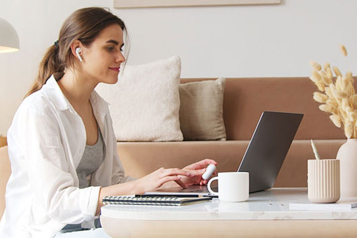 Eine Frau sitz am Laptop und arbeitet